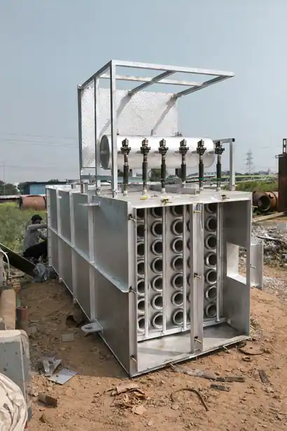 Internal view of an industrial dust collector showing the rows of fabric bag filter cages and pulse-jet valves during assembly
