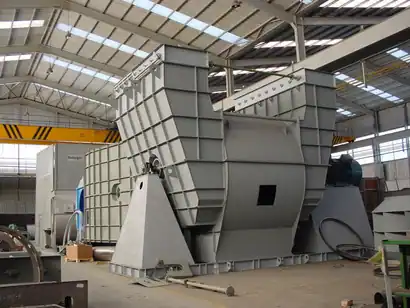 Large scale industrial centrifugal fan assembly inside a manufacturing workshop for boiler operations