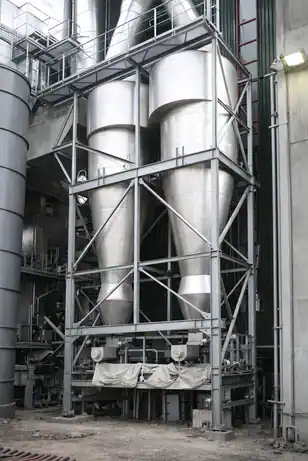 Industrial silver cyclone separator system permanently installed within a heavy steel support structure at a processing plant