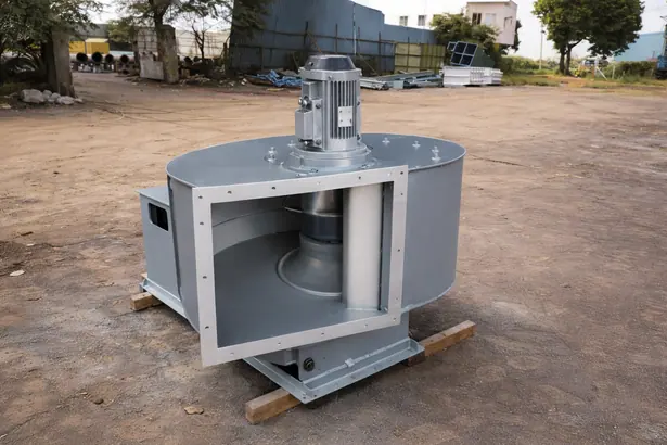 Industrial centrifugal fan unit on a wooden pallet showing the internal impeller wheel and top-mounted electric motor