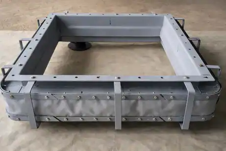 Rectangular fabric expansion joint with a light gray flexible membrane and external metal reinforcing bars